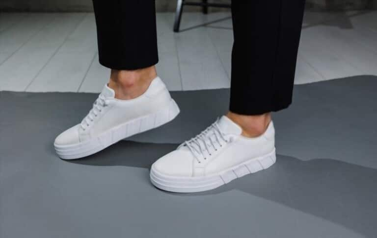 male legs with white sneakers and black pants