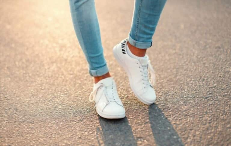 white sneakers and skinny jeans on asphalt sunset