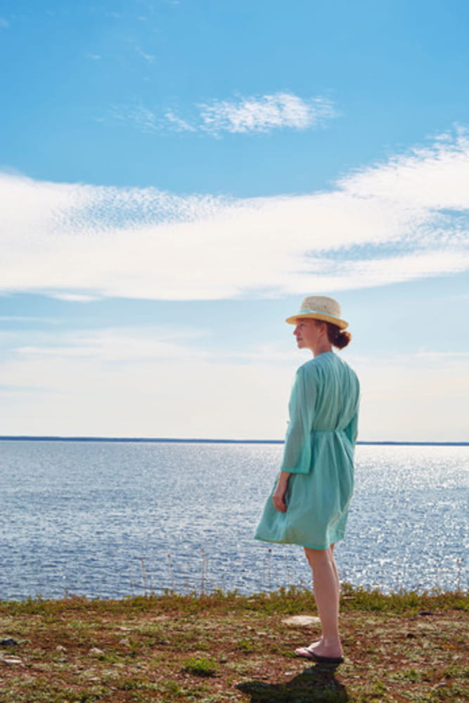 woman in turquoise dress looking at the sea