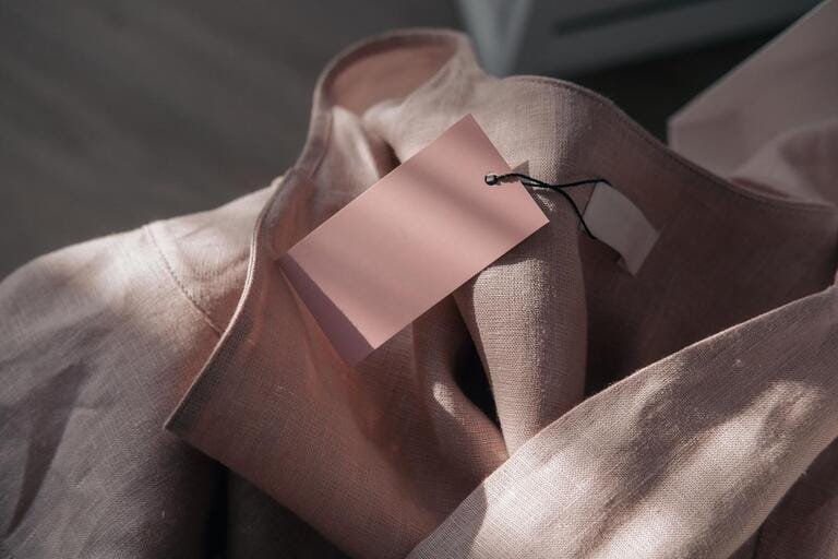 Pink linen dress with tags. Build fake branding. Fashion blog concept. Direct sunlight, light and shadow photography.